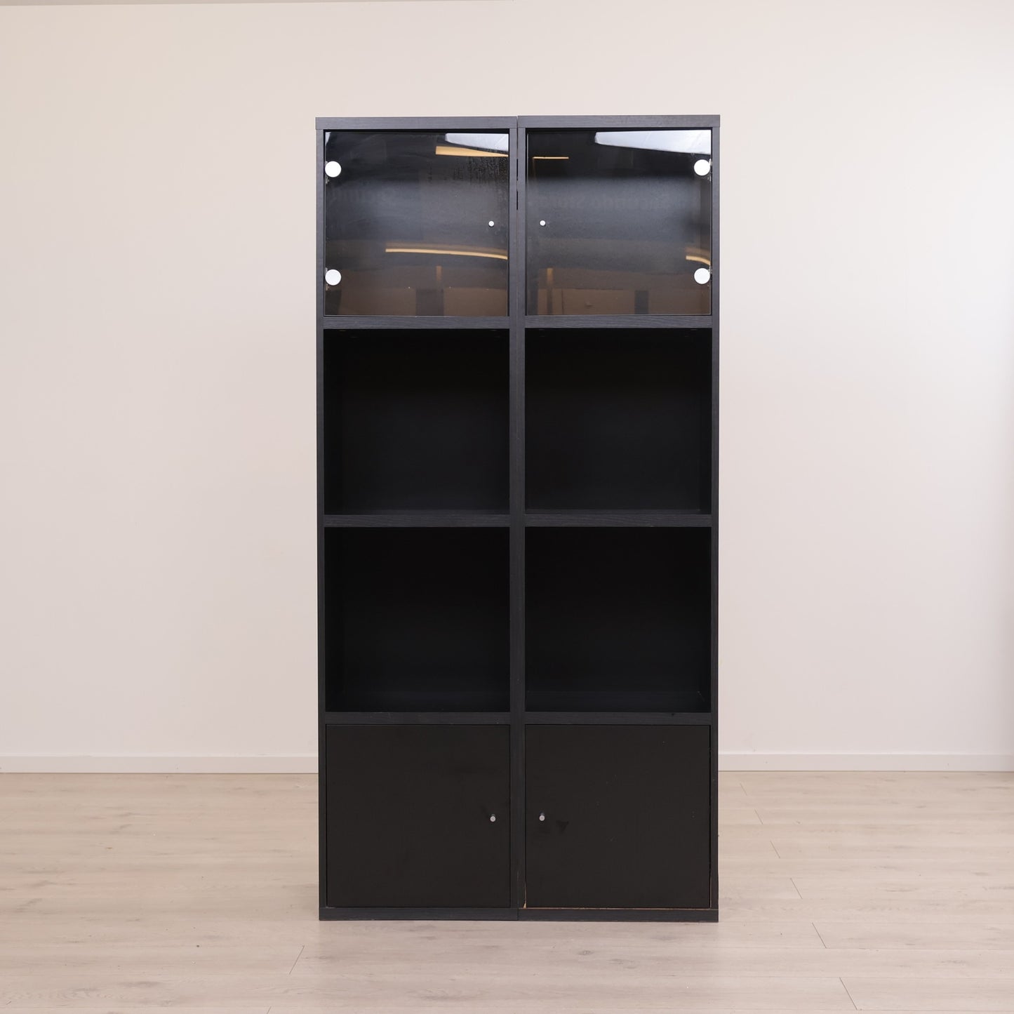 Moderne, sort skap med glass i topp og hyller i bunn