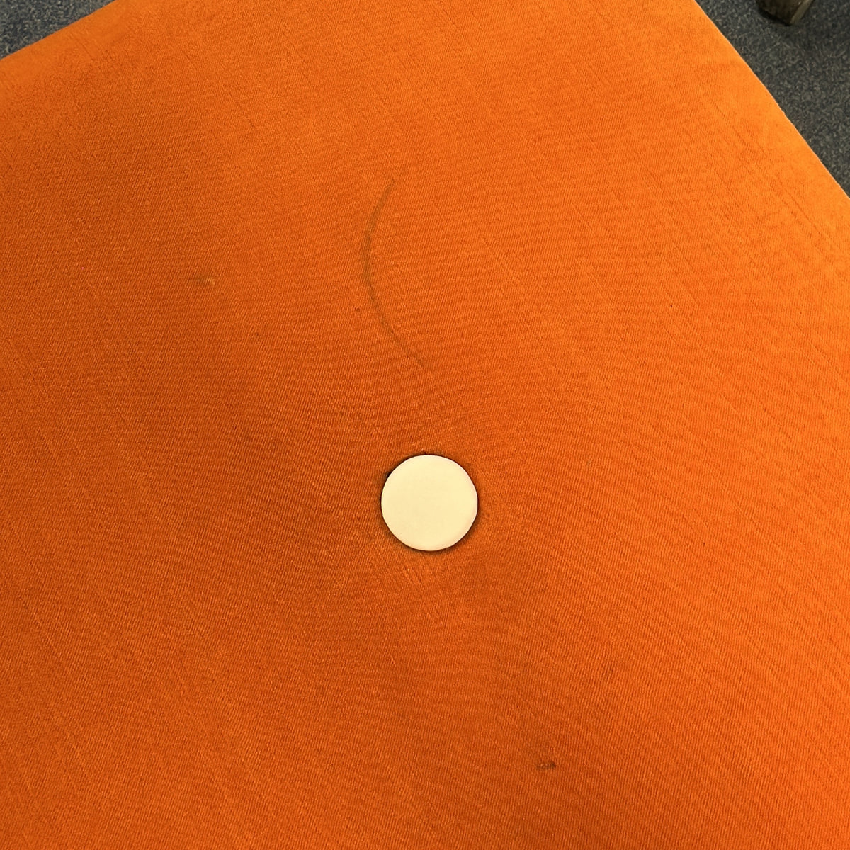 Puff i oransje, stoff med knapper