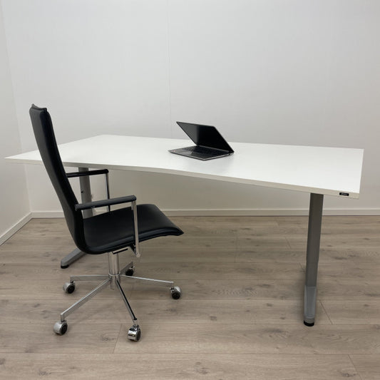 Manuell hev/senk skrivebord med hvit bordplate og magebue