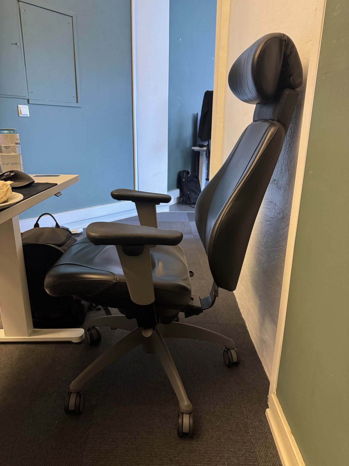 Kontorstol fra ISKU i svart, skinn med nakkestøtte